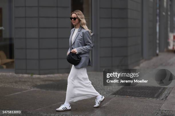 Isabelle Hartmann seen wearing YSL black sunglasses, House of Dagmar white silk long skirt, Vival Studio white cropped knit, silver earrings, Anine...