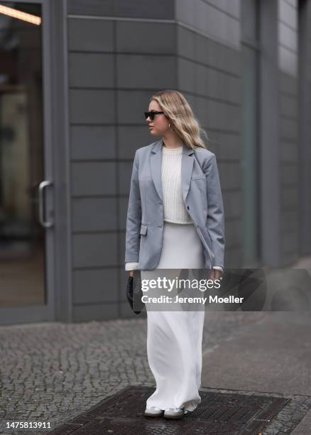 Isabelle Hartmann seen wearing YSL black sunglasses, House of Dagmar white silk long skirt, Vival Studio white cropped knit, silver earrings, Anine...