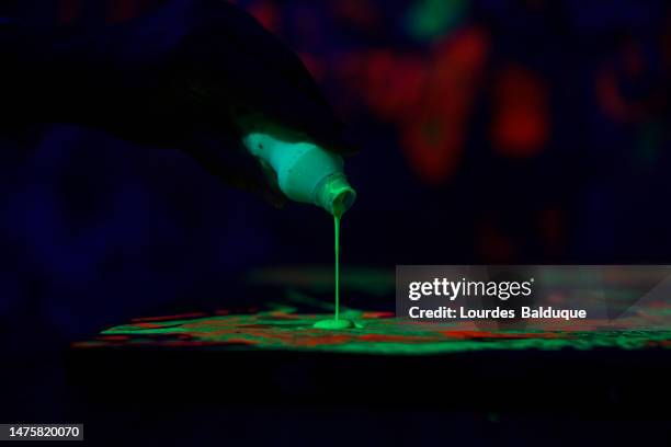 fluorescent paint in art studio - fluoreszierend stock-fotos und bilder