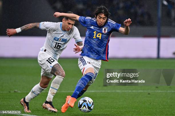 Junya Ito of Japan controls the ball against Mathias Olivera of Uruguay during the international friendly match between Japan and Uruguay at the...