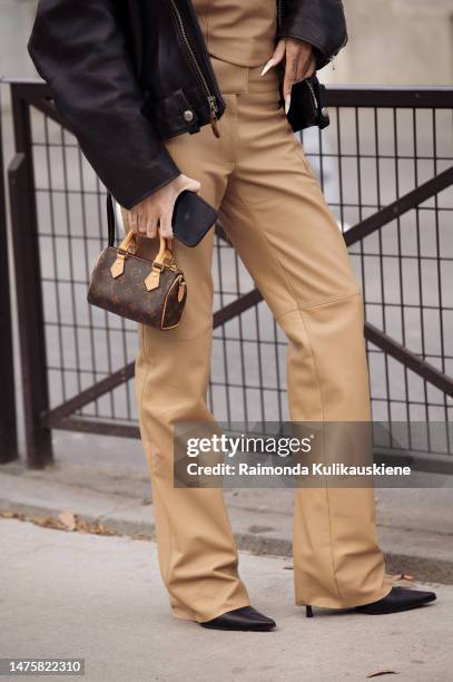 Guest is seen wearing beige leather pants, beige leather top, black leather jacket and brown Louis Vuitton bag outside Vaillant, during Paris Fashion...