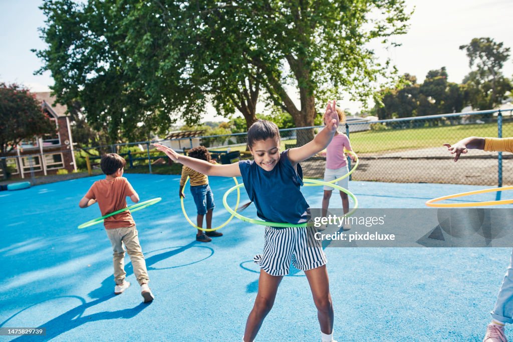 Children, hula hoop and friends playing outdoor together during break or recess on a school playground. Kids, games or fun with girl and boy students bonding while having fun outside during summer