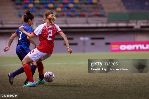 two opposing professional soccer players compete for possession of the ball. - full back soccer stock pictures, royalty-free photos & images