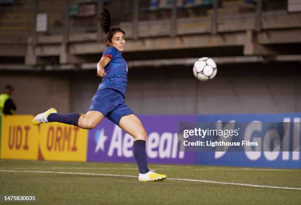 a professional female soccer player attempts to volley the soccer ball in the penalty box. - bait ball foto e immagini stock