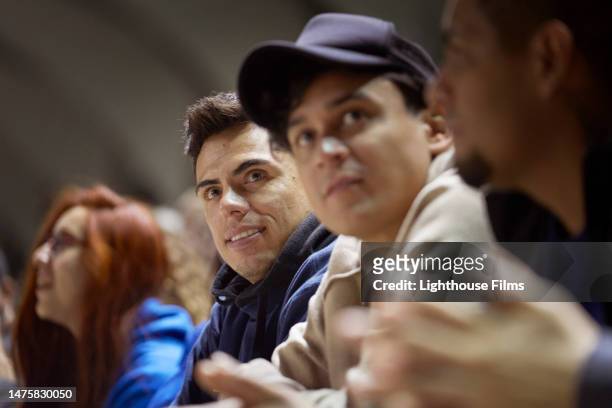 two sports fans look into the distance at a sports event. - crowd anticipation stock pictures, royalty-free photos & images