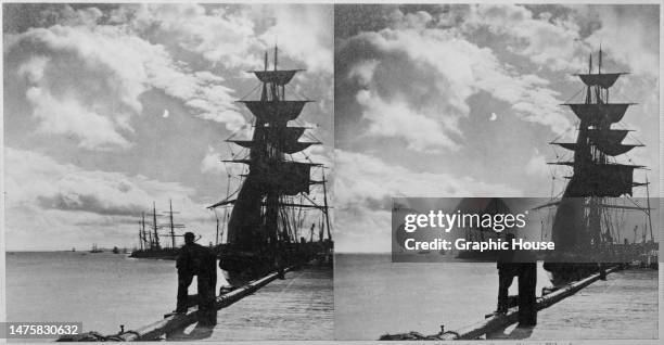 Stereoscopic image showing the silhouette of a man leaning against a mooring post, with ships visible on the Street Street Wharf on the waterfront of...