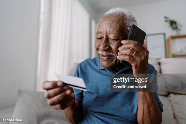 elderly man using smarphone and credit card - old man afro stock pictures, royalty-free photos & images