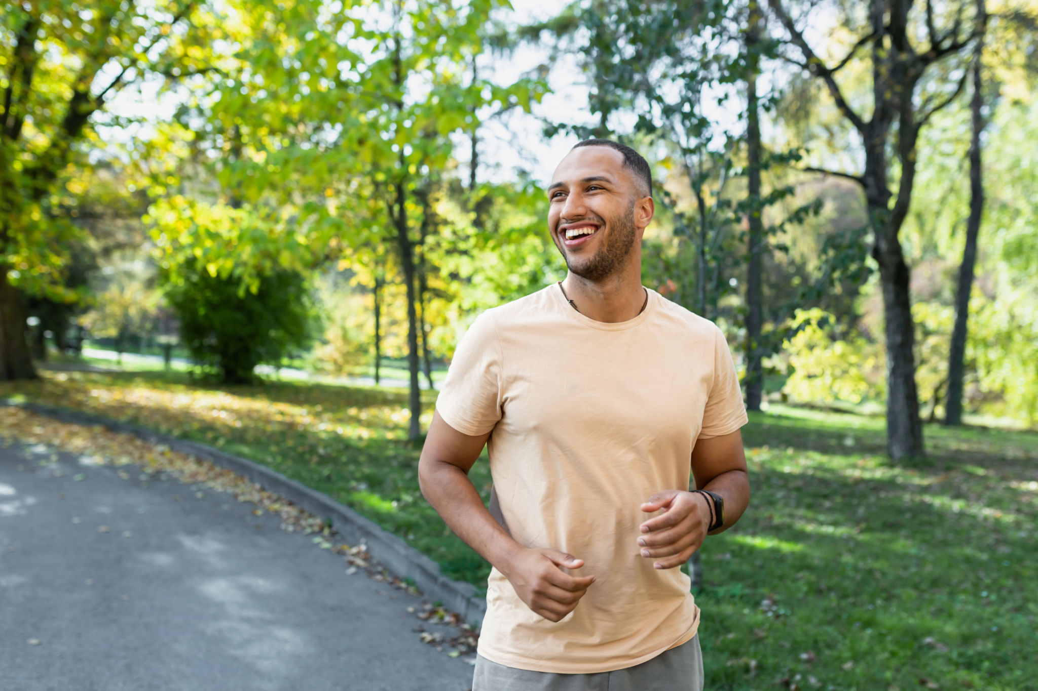 Cheerful and successful hispanic man jogging in the park, man running on a sunny day, smiling and happy having an outdoor activity Cheerful and successful hispanic man jogging in the park, man running on a sunny day, smiling and happy having an outdoor activity