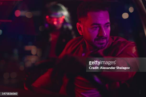 group portrait of people in car. neon light concept photography, futuristic photo with color lighting indoors the vehicle. man is driver, woman is passenger. people with glowing eyeglasses. - cyber punk girl stock pictures, royalty-free photos & images
