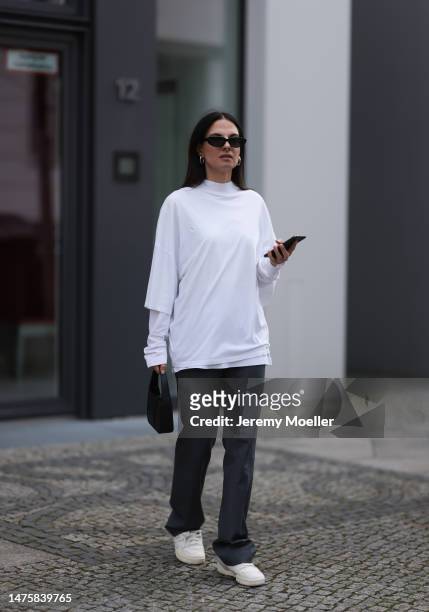 Anna Winter seen wearing Celine black sunglasses, silver earrings, Jil Sander white cotton shirt, The Frankie Shop grey pants, Weekday white...