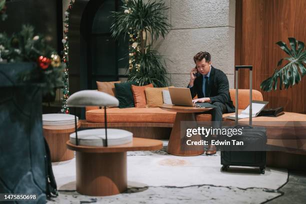 asian businessman talking over phone at airport lounge sitting on sofa - vip lounge stock pictures, royalty-free photos & images