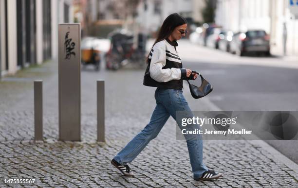 Anna Winter seen wearing Balenciaga black sunglasses, silver earrings, Prada black top with long sleeves, Weekday blue denim jeans, silver / black...