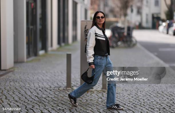 Anna Winter seen wearing Balenciaga black sunglasses, silver earrings, Prada black top with long sleeves, Weekday blue denim jeans, silver / black...