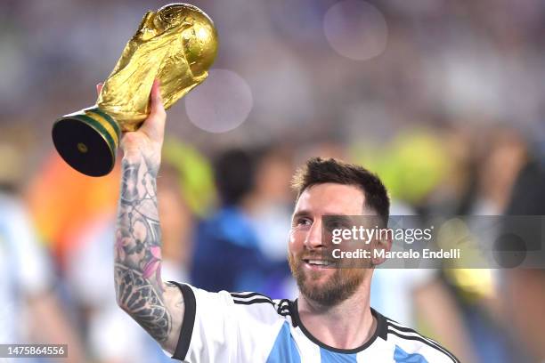 Lionel Messi of Argentina celebrates with the FIFA World Cup trophy during the celebrations after an international friendly match between Argentina...
