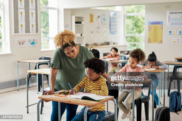 children classroom help, teacher and test writing of kids in a exam lecture hall for knowledge. education explanation, student learning and school employee in a study lesson with a young boy working - criança de escola primária imagens e fotografias de stock