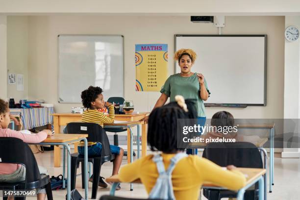 classroom, teacher and students in discussion about exam in a lecture hall for knowledge development. learning explanation, student help and school employee in test study lesson with children - junior high stock pictures, royalty-free photos & images