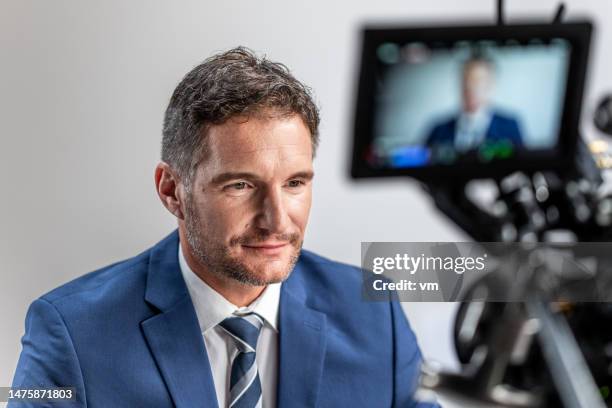 businessman sitting in front of camera - videoshoot stockfoto's en -beelden