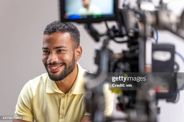 smiling man giving interview on camera - videoshoot stockfoto's en -beelden