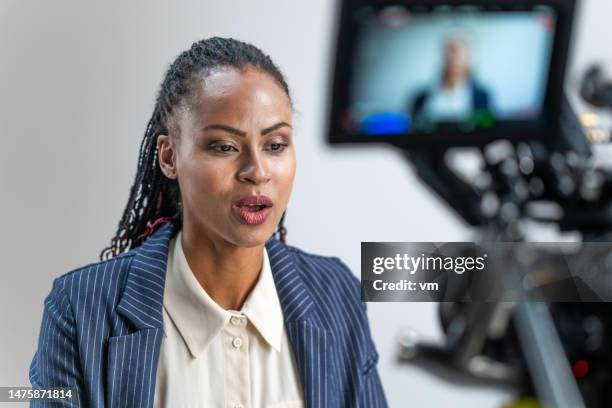 businesswoman giving interview on camera - videoshoot stockfoto's en -beelden