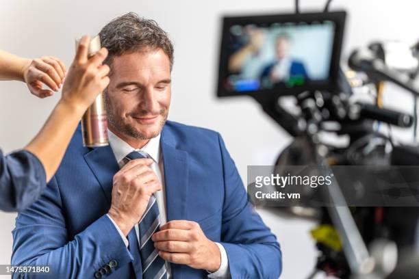 assistant preparing businessman for broadcast - videoshoot stockfoto's en -beelden