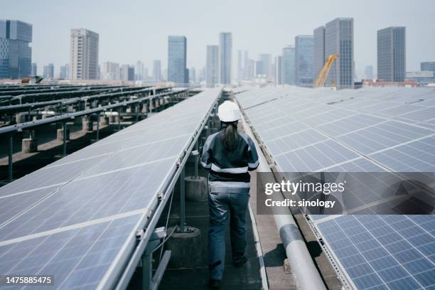 worker is inspecting the solar power station on the factory fooftop - panel de control fotografías e imágenes de stock