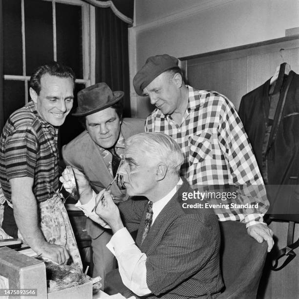 Actor Dickie Henderson , boxer Freddie Mills and author Emlyn Williams look at Bertie Hare applying stage makeup, May 4th 1960.