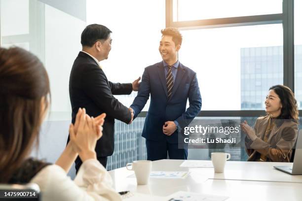 businesswoman and businessman shaking hands in modern office. - employee recognition stock pictures, royalty-free photos & images