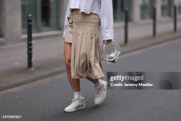 Victoria Thomas seen wearing Zara beige mini asymmetrical skirt and white cropped blouse, white socks, Mango transparent bag, Copenhagen Studios...