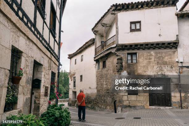 senior couple standing on the streets of covarrubias while visiting. - covarrubias stock pictures, royalty-free photos & images