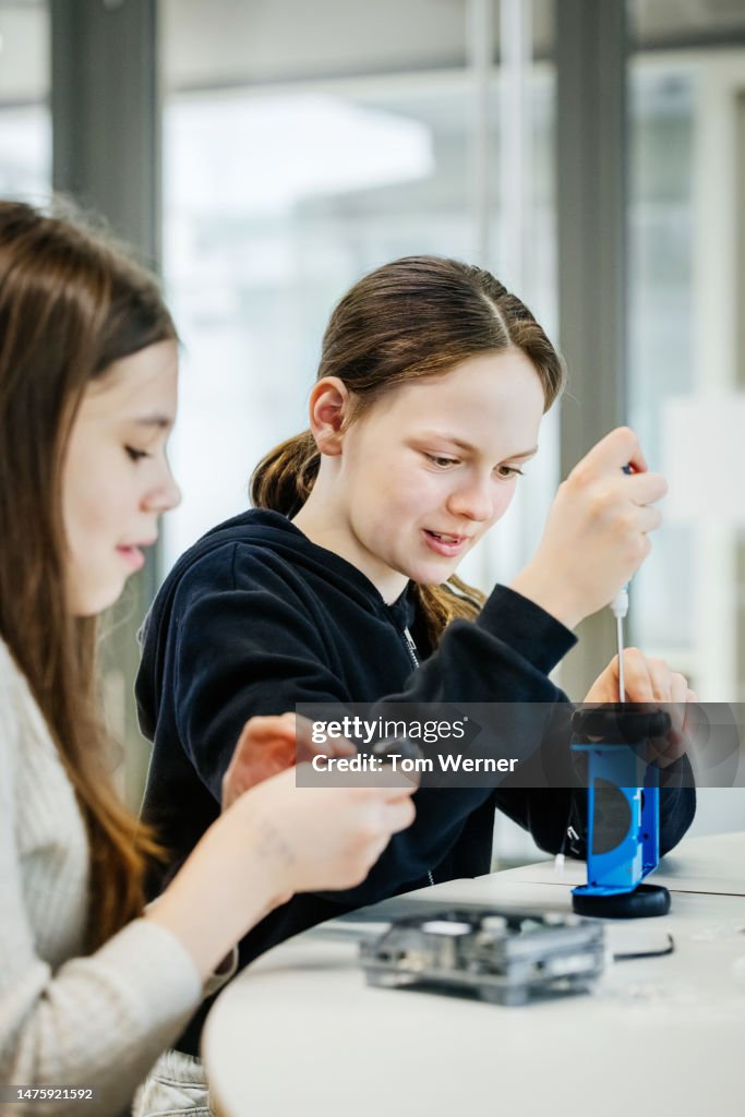 Young Girls Learning To Use Tools In Tech Workshop