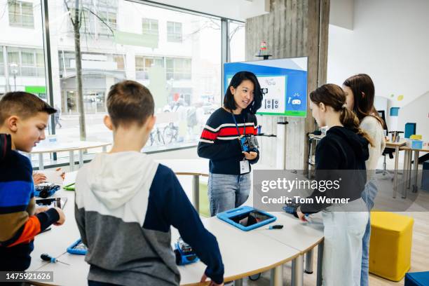 teacher talking to young students during tech workshop - building code stock pictures, royalty-free photos & images