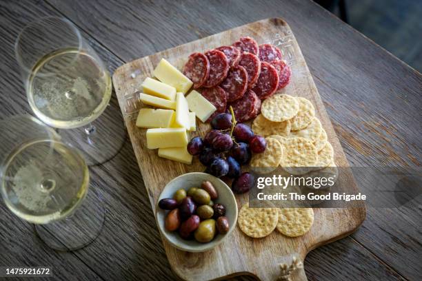 directly above shot of cheese board with wineglasses - aperitivo plato de comida fotografías e imágenes de stock