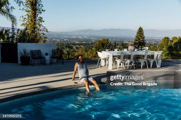 mature man enjoying vacation while sitting near swimming pool - la waterfront stock pictures, royalty-free photos & images