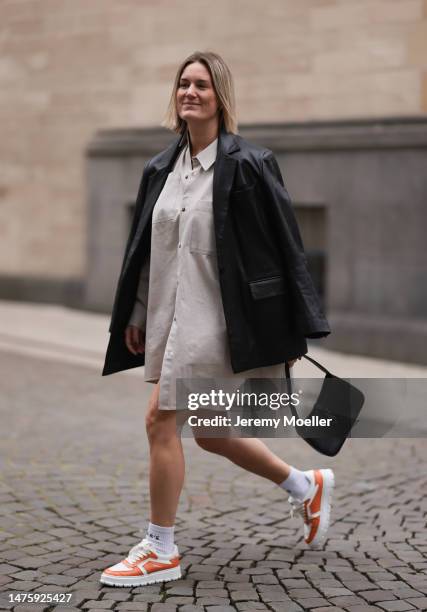 Victoria Thomas seen wearing By Aylin Koenig beige oversized shirt, gold jewelry, Oval Square black leather jacket, YSL black leather gold logo bag,...