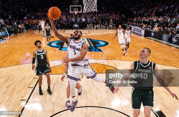 Markquis Nowell of the Kansas State Wildcats shoots the ball against Joey Hauser of the Michigan State Spartans during overtime in the Sweet 16 round...