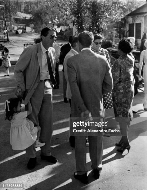 Actor Gregory Peck hanging out while his daughter Cecilia swings from his legs, in 1061 at Monroeville, Alabama.