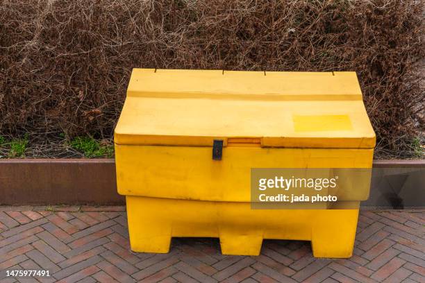 yellow grit salt box standing on the street in front of a thicket - snow melting on sidewalk stock pictures, royalty-free photos & images