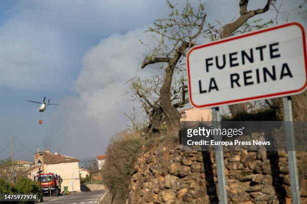 View of a helicopter and a column of smoke caused by a forest fire originating in Villanueva de Viver, at the entrance of the municipality of Fuente...