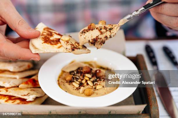 man eating hummus with pita bread, close-up - cucina del medio oriente foto e immagini stock