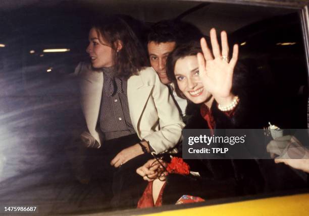 Canadian activist Margaret Trudeau waves to photographers as she leaves in a taxi with unidentified friends after watching Mikhail Baryshnikov's...