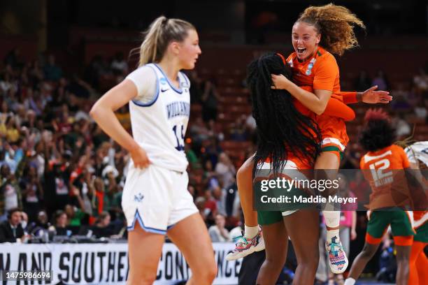 Lola Pendande of the Miami Hurricanes celebrates with Kenza Salgues of the Miami Hurricanes after beating the Villanova Wildcats 70-65 in the Sweet...