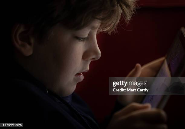 Year-old boy looks at a iPad screen on March 16, 2023 in Bath, England. The amount of time children spend on screens each day rocketed during the...