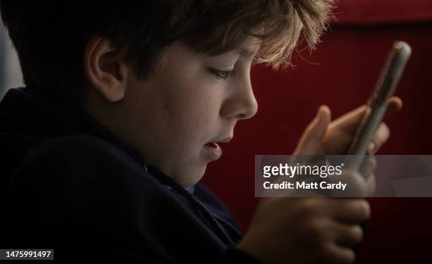 Year-old boy looks at a iPad screen on March 16, 2023 in Bath, England. The amount of time children spend on screens each day rocketed during the...