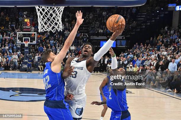 Jaren Jackson Jr. #13 of the Memphis Grizzlies goes to the basket against Maxi Kleber of the Dallas Mavericks and Kyrie Irving of the Dallas...