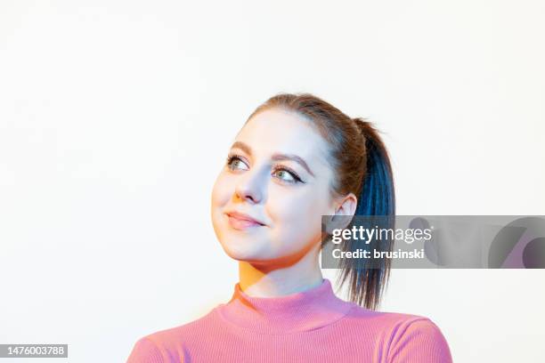 close up studio portrait of young white cheerful woman. with neon light effect - three quarter front view stock pictures, royalty-free photos & images