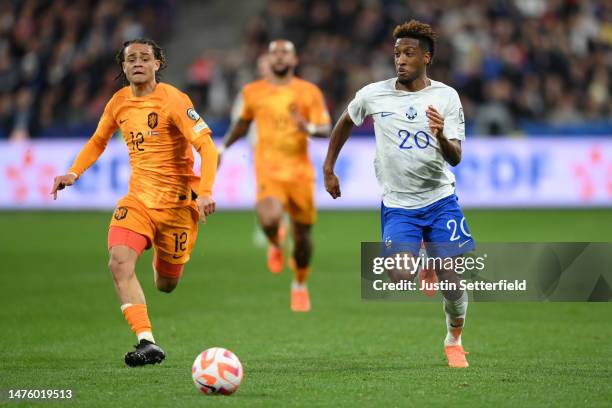 Kingsley Coman of France runs with the ball while under pressure from Xavi Simons of Netherlands during the UEFA EURO 2024 qualifying round group B...