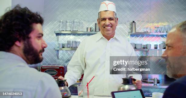 restaurant owner in white button down shirt holding coffee pots - 50s diner stock pictures, royalty-free photos & images