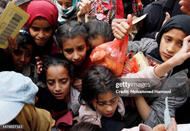 Girls from families affected by eight years of war and blockade receive free meals provided by a charitable kitchen in the Mseek area on March 23,...