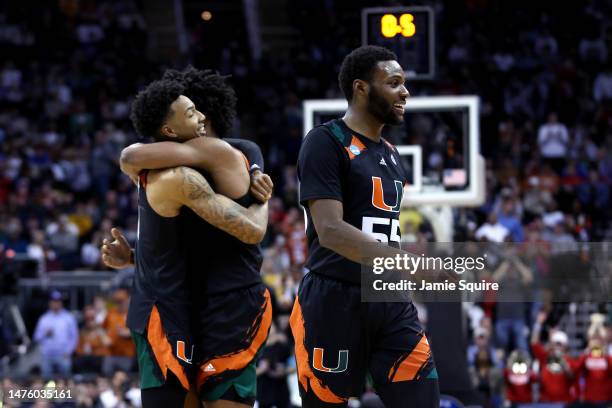 Wooga Poplar, Jordan Miller and Norchad Omier of the Miami Hurricanes celebrate after defeating the Houston Cougars 89-75 during the Sweet 16 round...