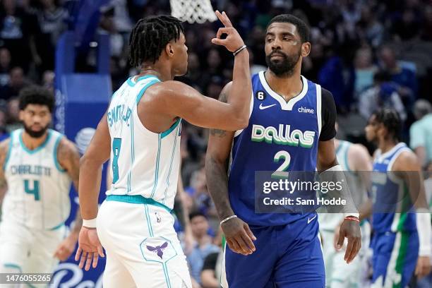 Dennis Smith Jr. #8 of the Charlotte Hornets celebrates in front of Kyrie Irving of the Dallas Mavericks after scoring a three-point basket late in...